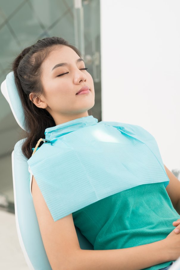 Napping patient man smiling in dentists chair