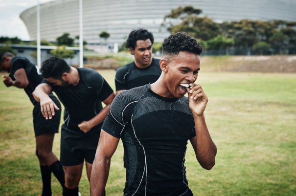 Its half-time. Cropped shot of a handsome young rugby player removing his mouthguard during half-time on the field. man smiling in dentists chair