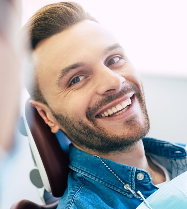 A perfect result of a dentists work which is seen in the beautiful and white smile on a patient who is absolutely satisfied with a result of a treatment given in a clinic. man smiling in dentists chair